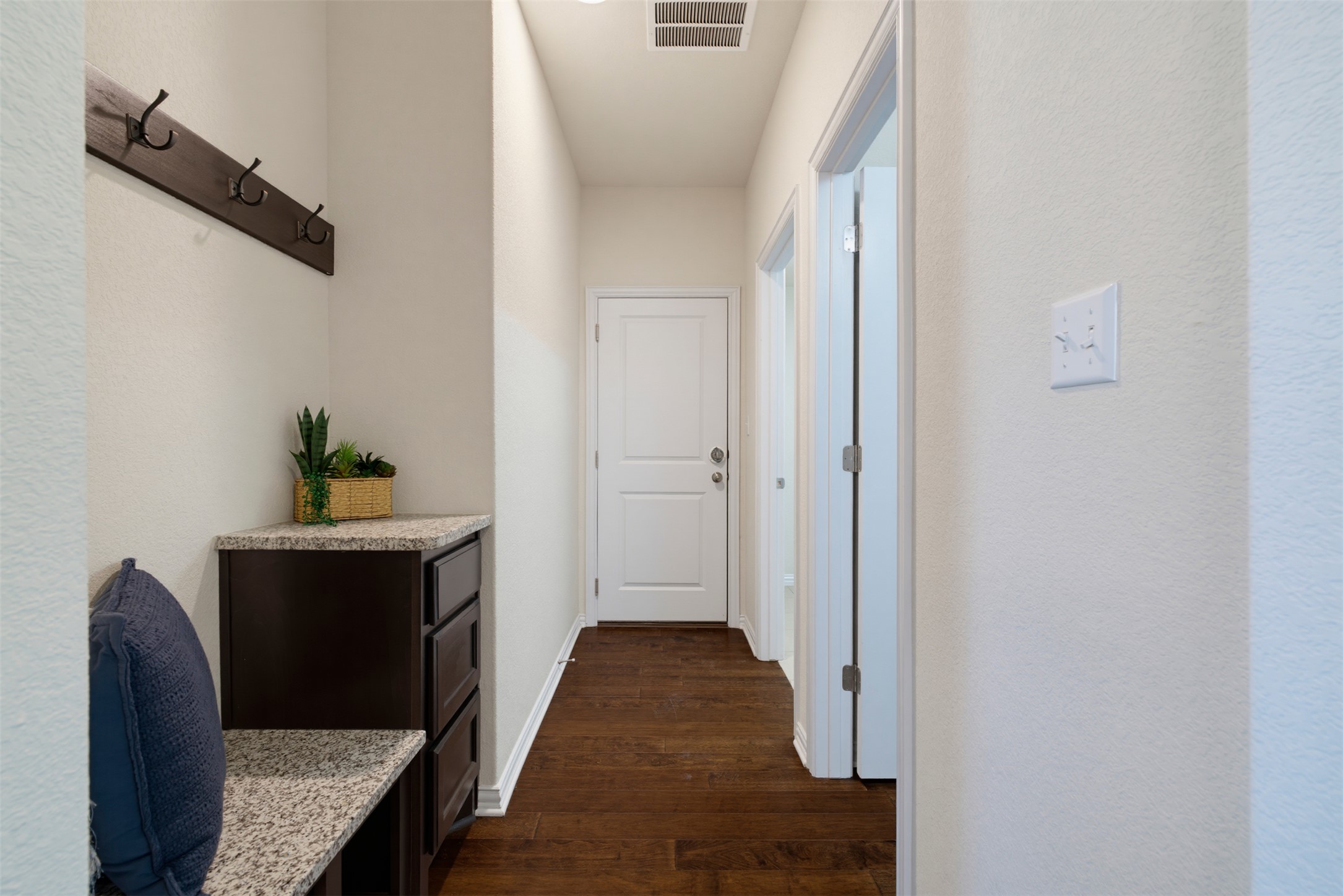12613 Twisted Root Drive Manchaca, TX 78652 - Photo 30 of 33 Rich hardwood floors lead the way down a functional, well-appointed hallway with convenient built-in storage.
