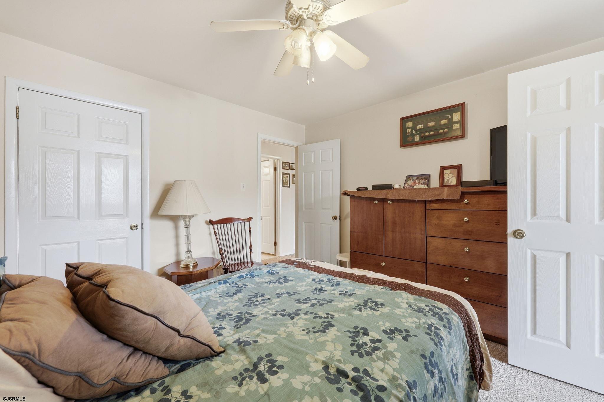598 Mays Landing Road, Unit 202 Somers Point, NJ 08244 - Photo 13 of 23 a bedroom with a bed and a chandelier