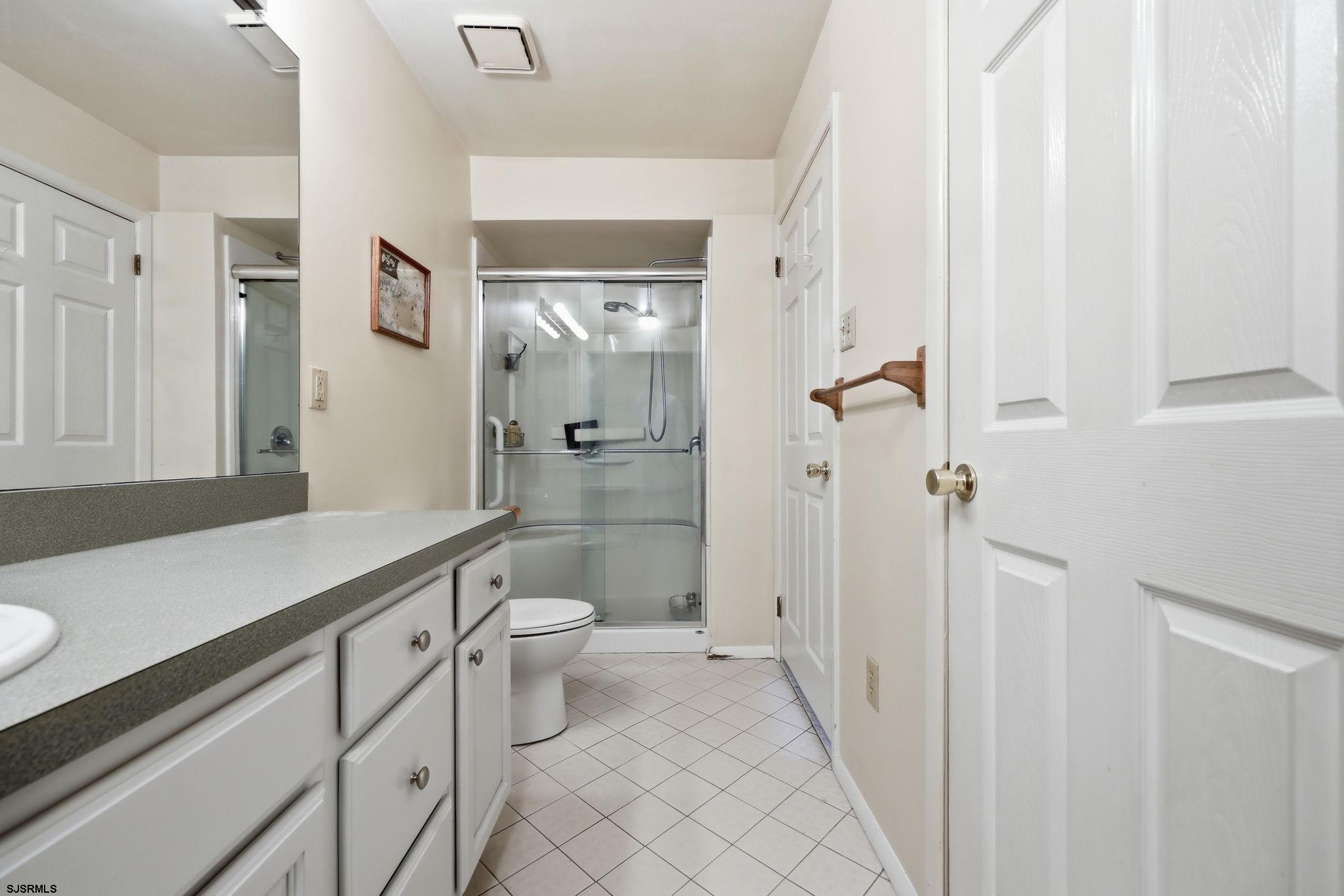598 Mays Landing Road, Unit 202 Somers Point, NJ 08244 - Photo 16 of 23 a bathroom with a sink a toilet a shower and a mirror