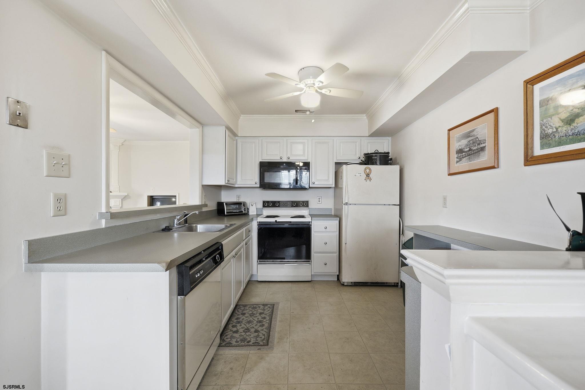 598 Mays Landing Road, Unit 202 Somers Point, NJ 08244 - Photo 6 of 23 a kitchen with a sink stove and refrigerator