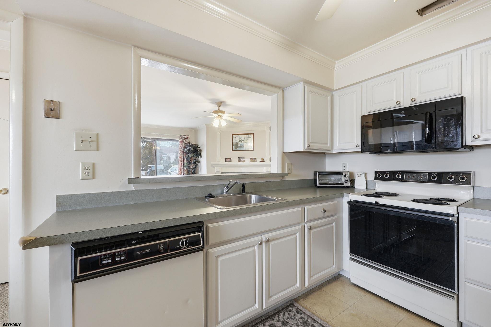 598 Mays Landing Road, Unit 202 Somers Point, NJ 08244 - Photo 7 of 23 a kitchen with stainless steel appliances granite countertop a sink dishwasher a stove and a microwave oven with cabinets