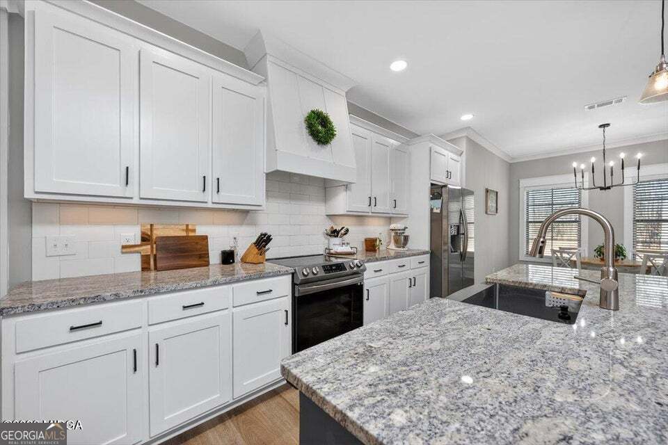 303 Tuxedo Circle Forsyth, GA 31029 - Photo 12 of 45 a kitchen with granite countertop white cabinets and stainless steel appliances