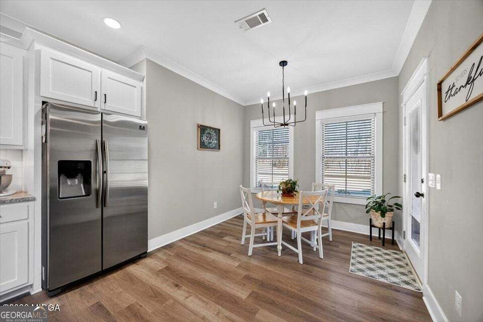 303 Tuxedo Circle Forsyth, GA 31029 - Photo 14 of 45 a dining room with furniture a chandelier and wooden floor