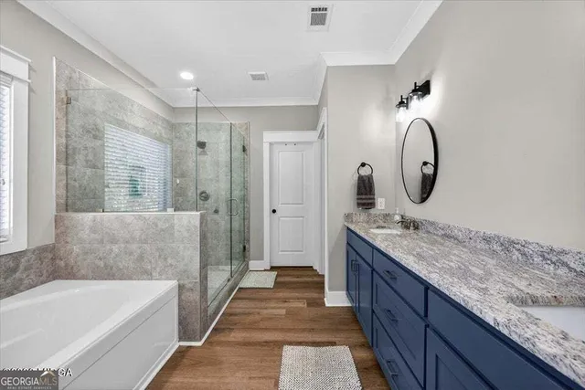 a bathroom with a granite countertop tub a double vanity sink and a mirror