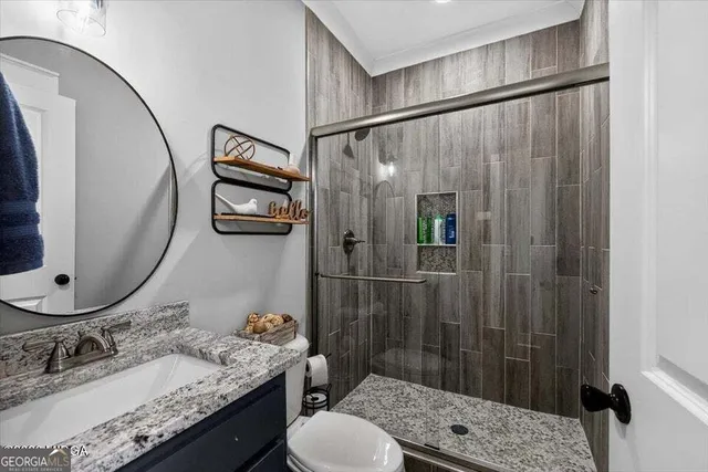 a bathroom with a granite countertop sink toilet and shower