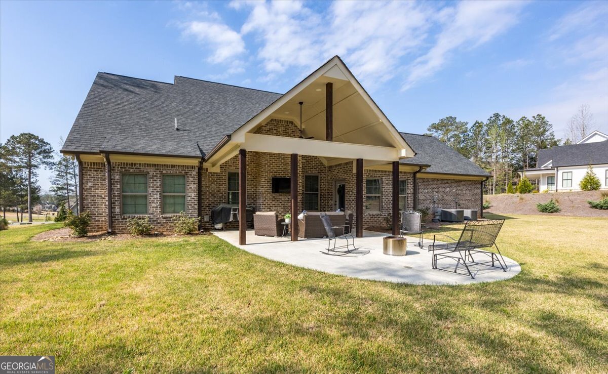 303 Tuxedo Circle Forsyth, GA 31029 - Photo 30 of 45 a patio with a table and chairs and potted plants