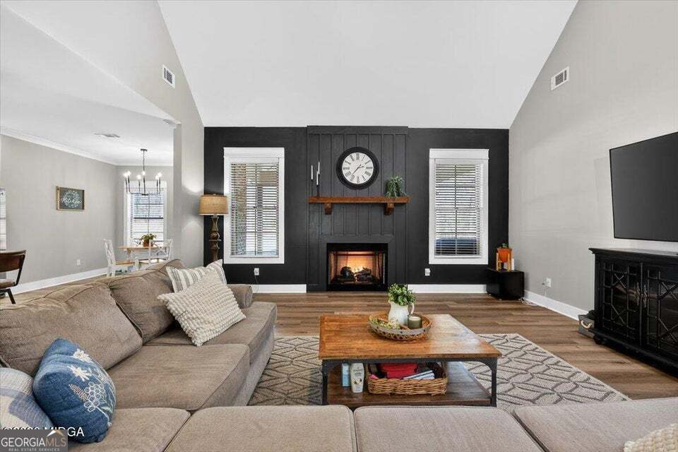 303 Tuxedo Circle Forsyth, GA 31029 - Photo 4 of 45 a living room with furniture a fireplace and a flat screen tv