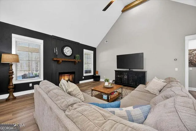 a living room with furniture a fireplace and a flat screen tv