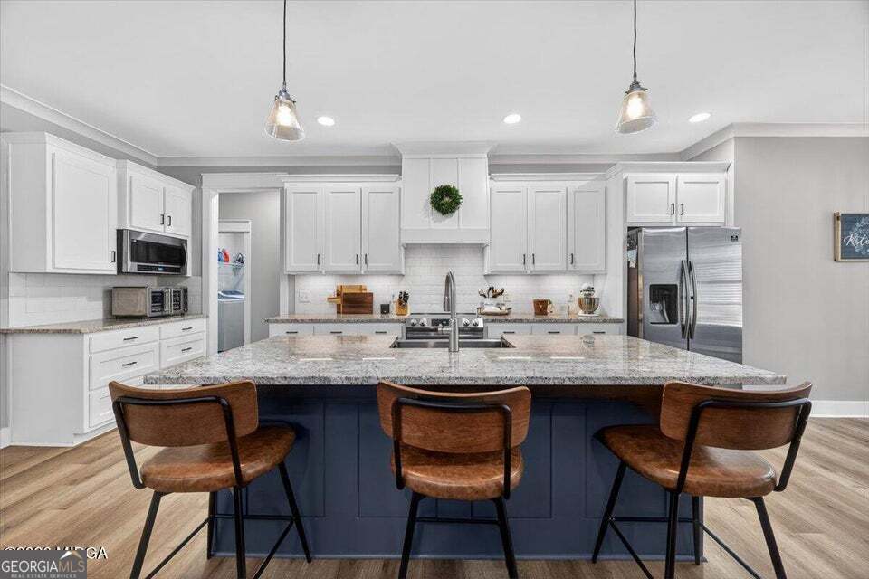 303 Tuxedo Circle Forsyth, GA 31029 - Photo 10 of 45 a kitchen with stainless steel appliances granite countertop a sink a stove a dining table and chairs