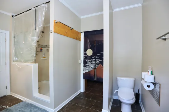 a bathroom with a toilet and a shower