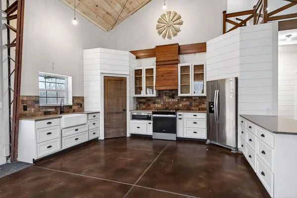 a kitchen with stainless steel appliances granite countertop a refrigerator and a stove