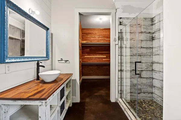 a view of an empty room with wooden floor and stairs