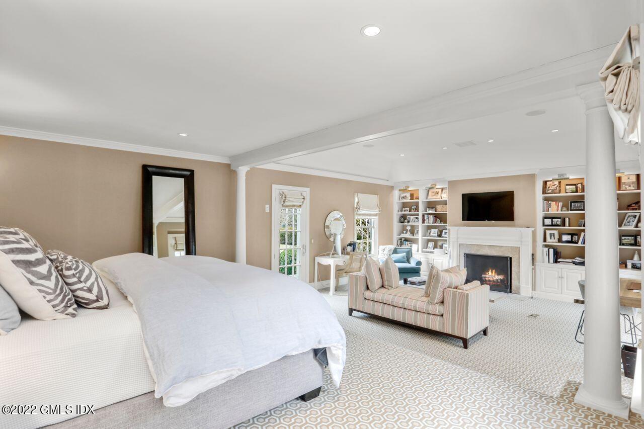 415 Round Hill Road Greenwich, CT 06831 - Photo 16 of 36 a spacious bedroom with a large bed and a fireplace