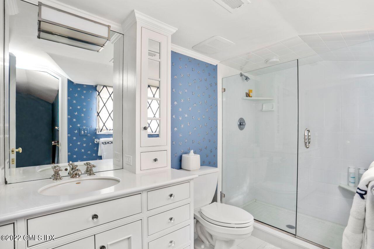 415 Round Hill Road Greenwich, CT 06831 - Photo 23 of 36 a bathroom with a granite countertop sink toilet a large mirror a shower and a mirror