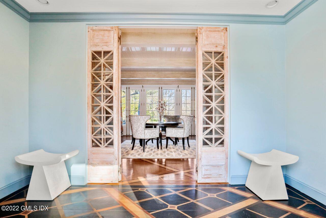 415 Round Hill Road Greenwich, CT 06831 - Photo 4 of 36 a living room with a table and a chandelier