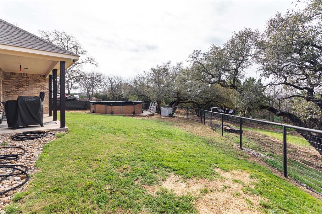 223 Cottongame Road Weatherford, TX 76088 - Photo 33 of 39 a view of a garden with a bench in the patio