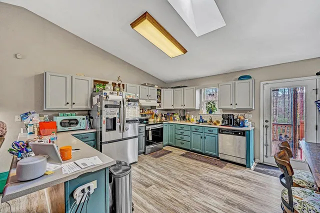 a kitchen with a refrigerator a stove and wooden floor