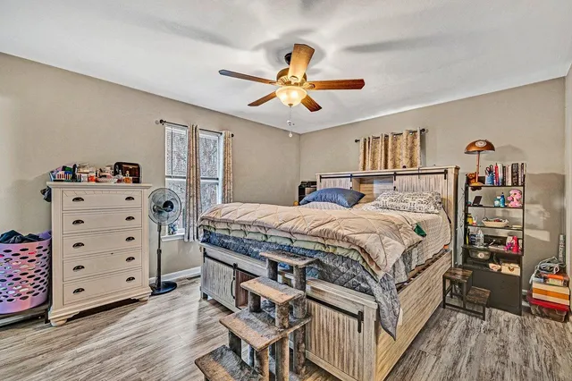 a bedroom with a bed and wooden floor