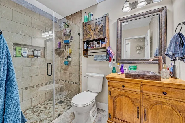 a bathroom with a sink a toilet and shower