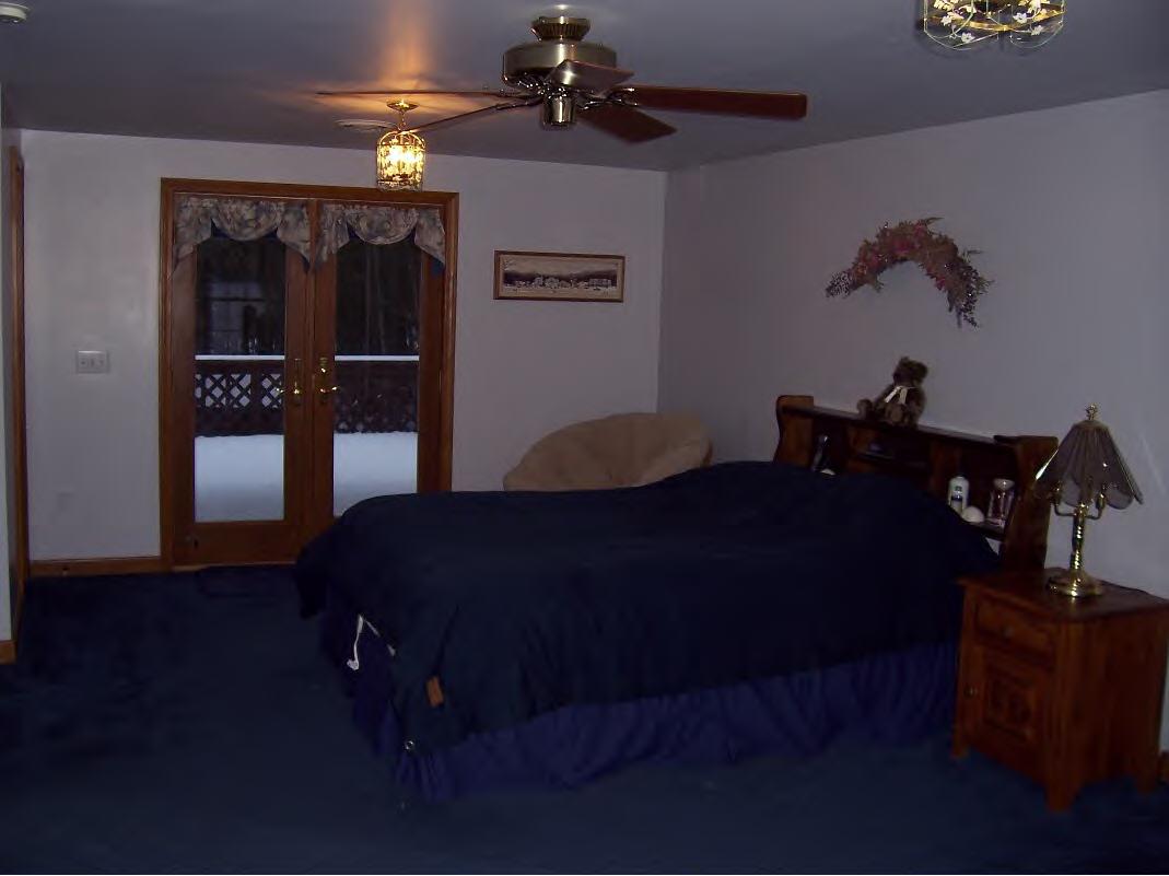 158 Bunce Road South Sheffield, MA 01222 - Photo 4 of 6 a bedroom with a bed and a chandelier