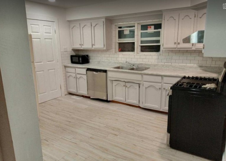 481 West Broad Street Smithville, TN 37166 - Photo 17 of 27 a kitchen with granite countertop white cabinets and black appliances
