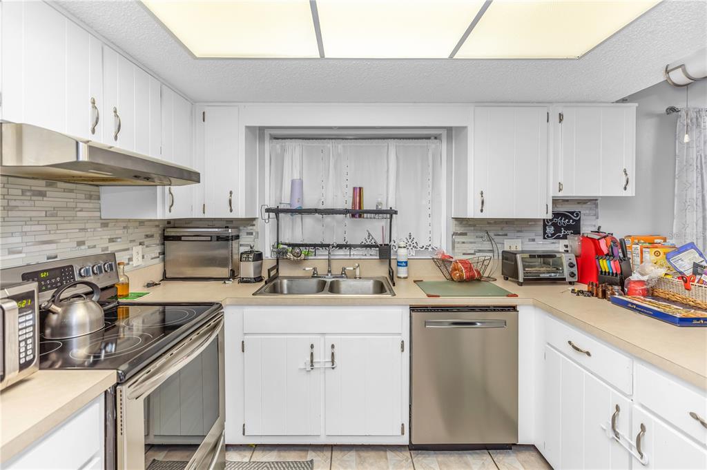 1186 Azora Drive Deltona, FL 32725 - Photo 4 of 24 a kitchen with a sink a stove and cabinets