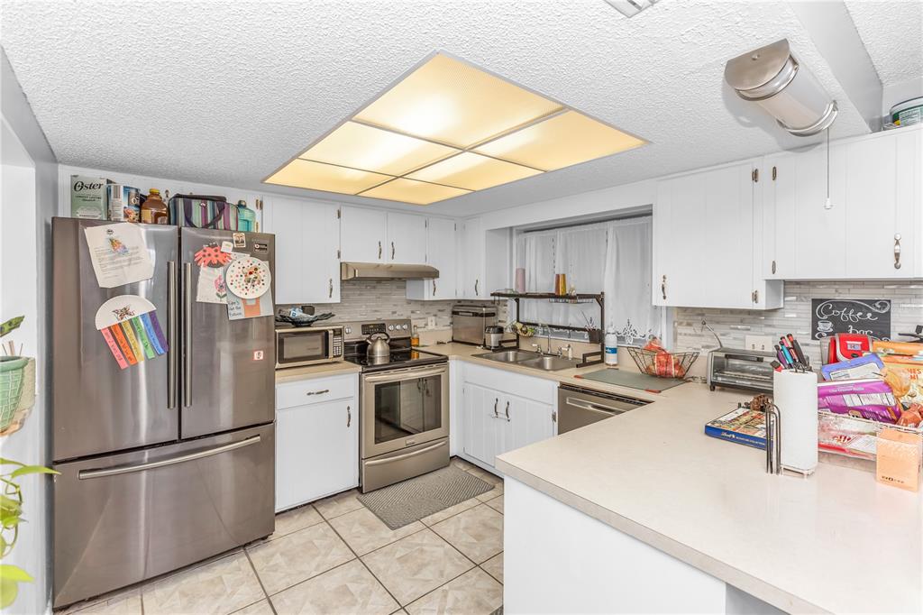 1186 Azora Drive Deltona, FL 32725 - Photo 5 of 24 a kitchen with refrigerator and cabinets