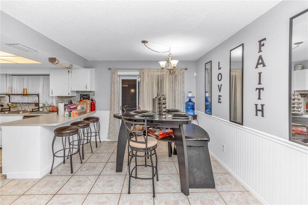 1186 Azora Drive Deltona, FL 32725 - Photo 8 of 24 a kitchen with stainless steel appliances a table and chairs in it