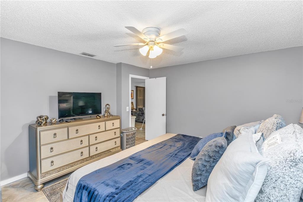 1186 Azora Drive Deltona, FL 32725 - Photo 10 of 24 a bedroom with a bed and a flat screen tv on dresser