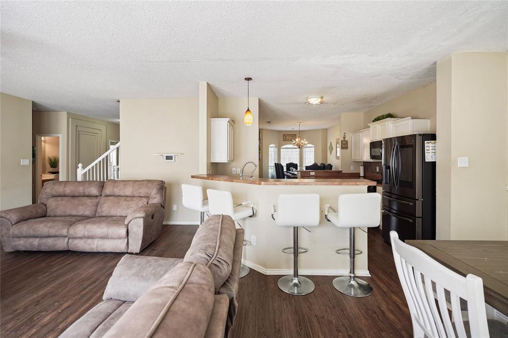 1934 Pin Oak Lane Lancaster, TX 75146 - Photo 11 of 27 a living room with stainless steel appliances kitchen island granite countertop furniture and a wooden floor