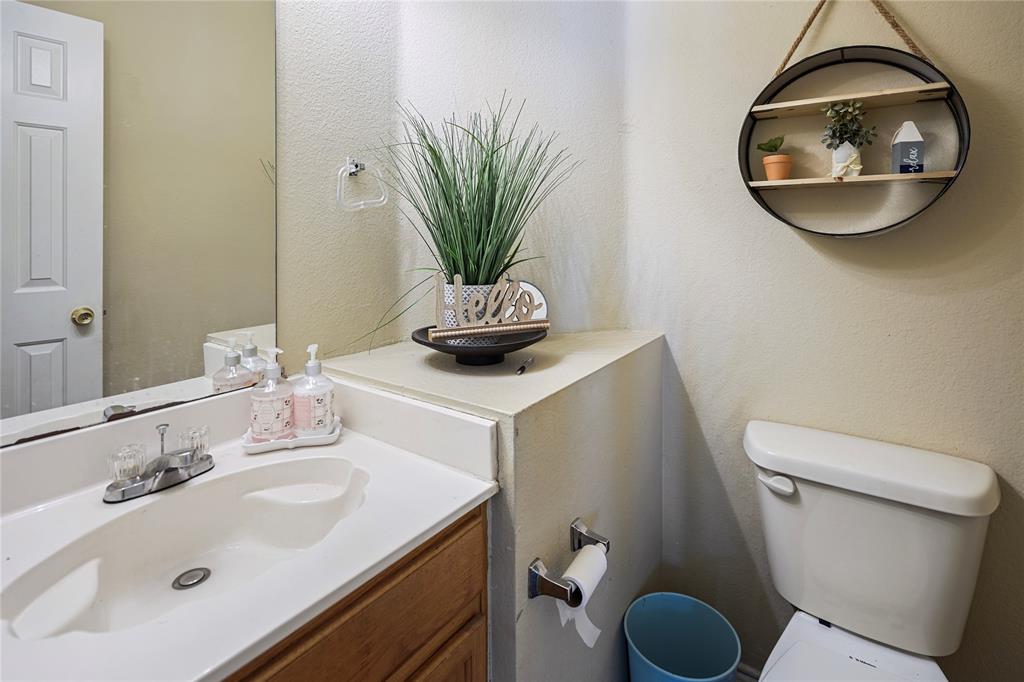 1934 Pin Oak Lane Lancaster, TX 75146 - Photo 14 of 27 a bathroom with a toilet a sink and mirror
