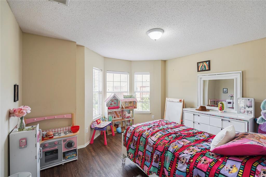 1934 Pin Oak Lane Lancaster, TX 75146 - Photo 25 of 27 a bedroom with a bed and wooden floor