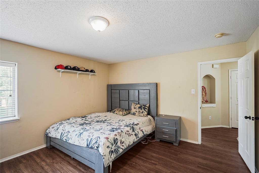 1934 Pin Oak Lane Lancaster, TX 75146 - Photo 26 of 27 a bedroom with a bed and wooden floor