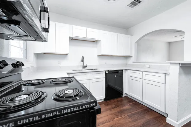 a kitchen with a stove and wooden cabinets