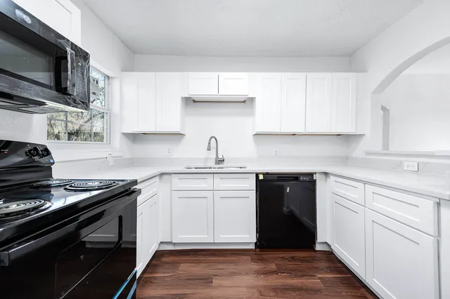 a kitchen with a sink stove top oven and cabinets