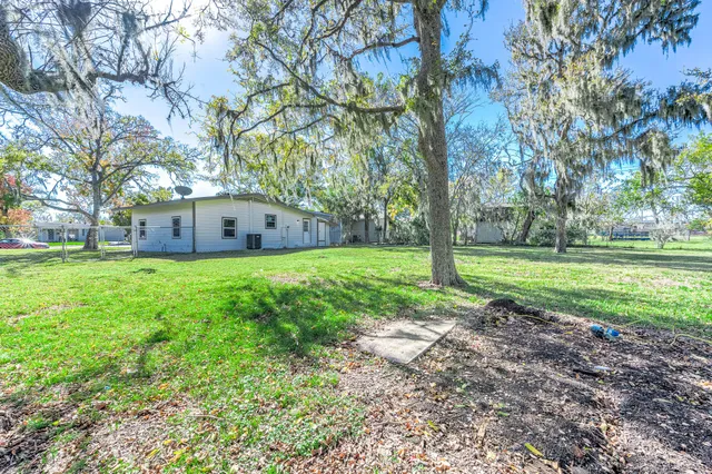 a view of a house with yard and tree s