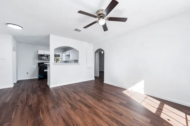 a view of a kitchen with wooden floor and a ceiling fan