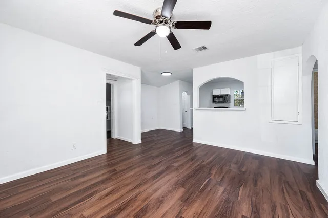 a view of a kitchen with wooden floor and a ceiling fan