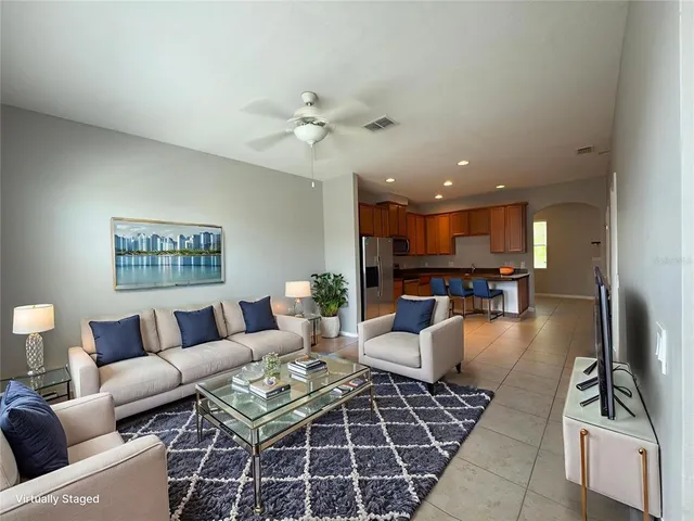 a living room with furniture and a view of kitchen