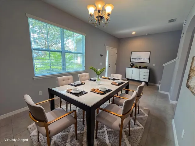 a view of a dining room with furniture and a chandelier