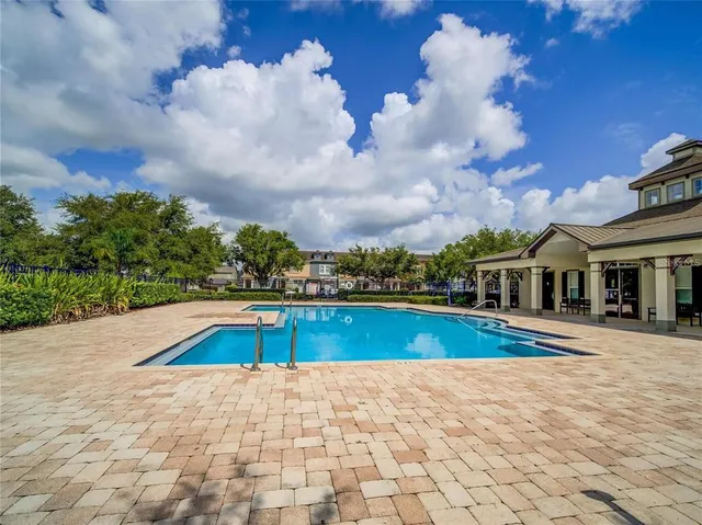 a view of pool with yard in front of house
