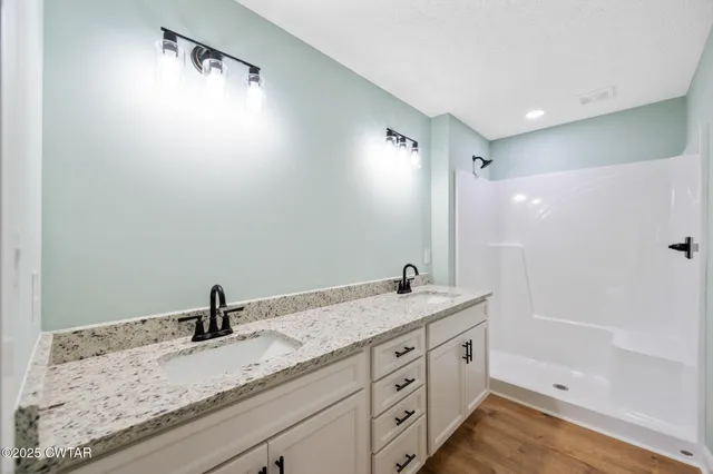 a bathroom with a granite countertop sink and a mirror
