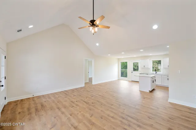 a view of empty room with wooden floor and window