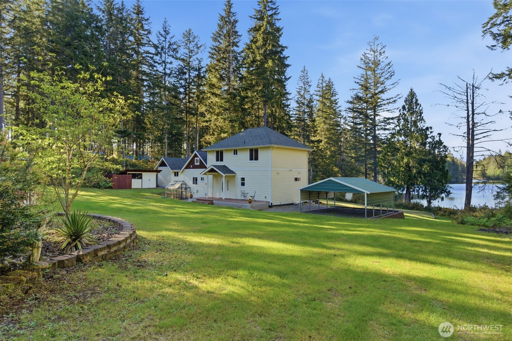6971 Northeast Tahuya Blacksmith Road Belfair, WA 98528 - Photo 35 of 38 a view of a house with a big yard and large trees
