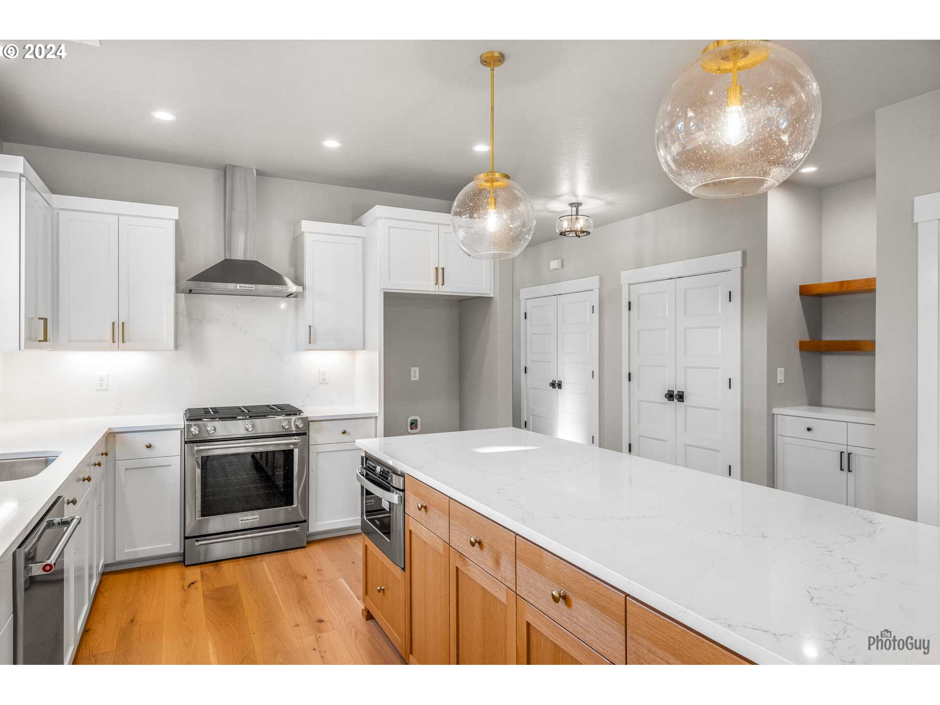 32748 Coburg Road Eugene, OR 97408 - Photo 15 of 35 a kitchen with kitchen island a stove a sink and a refrigerator