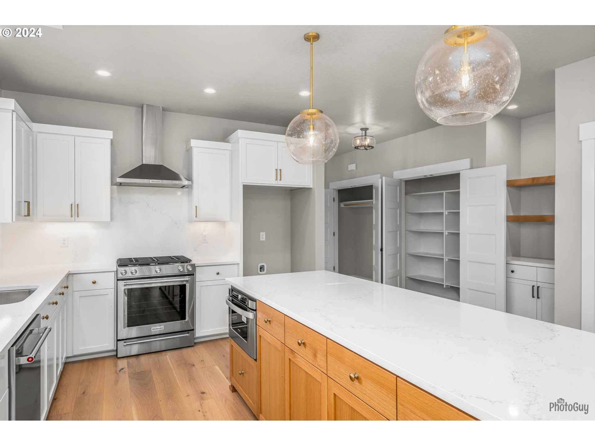 32748 Coburg Road Eugene, OR 97408 - Photo 16 of 35 a kitchen with kitchen island a stove a sink and a refrigerator