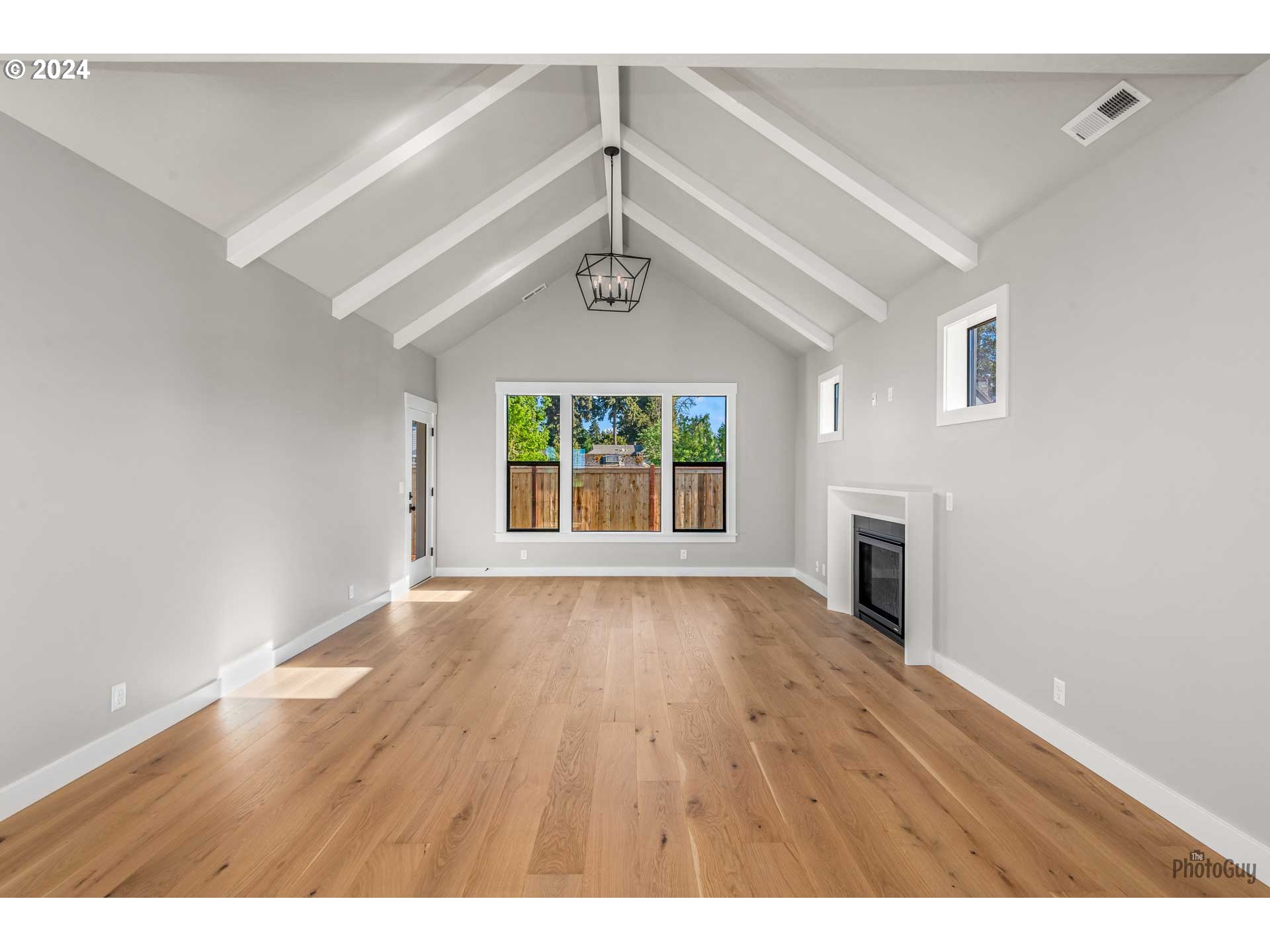 32748 Coburg Road Eugene, OR 97408 - Photo 7 of 35 a view of an empty room with wooden floor and a window
