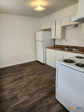 a kitchen with granite countertop a stove and a refrigerator