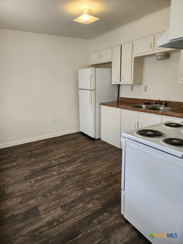 309 Sunset Lane, Unit G Copperas Cove, TX 76522 - Photo 3 of 5 a kitchen with granite countertop a stove and a refrigerator