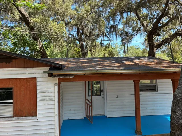 a yellow house with trees in front of it